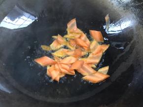 锅置火上，加入食用油，放入胡萝卜炒断生