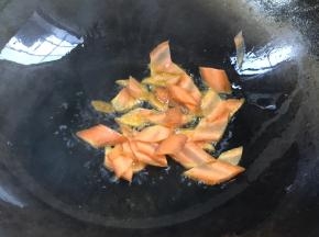 锅置火上，加入食用油，放入胡萝卜炒断生