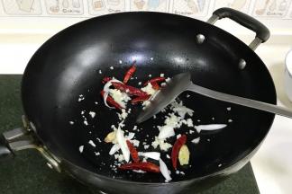 在锅内倒入适量食用油，加入干辣椒、葱白、姜片、蒜蓉炒香。