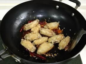 加入炸好的鸡翅，翻炒几下。