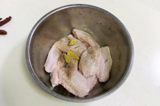 往鸡翅内加入盐、黑胡椒和姜片。