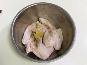 往鸡翅内加入盐、黑胡椒和姜片。
