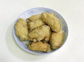 鸡翅炸至金黄色，约10分钟左右即可捞出，然后再入锅复炸一次备用。