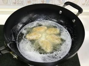 食用油加至7～8分热时，把鸡翅放入锅中转中火炸制，鸡翅放入锅时不要急于翻动，大约1～2分钟后再去翻动。