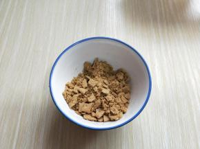 将饼干取出包装，放入小碗里，用擀面杖的一端捣碎立刻。（可以根据个人喜欢来选择饼干碎的程度，我喜欢有点颗粒感，所以没有捣的特别碎）