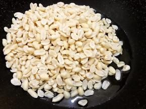 倒入冻好的花生米再开中火不停的翻炒