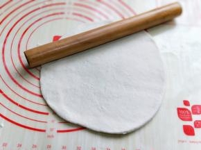 面团发酵至原来两倍大，取出排气，盖上保鲜膜松弛10分钟，再用擀面杖擀圆。