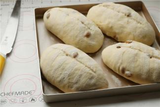 当面团胚子变得饱满而富有弹性，撒上粉，割口，花纹什么的自己随意就行。