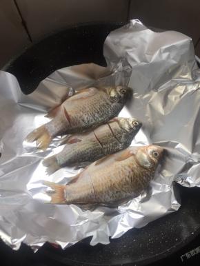 把腌制好的鲫鱼放在锡纸上。