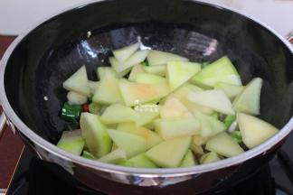 这个时候加入切好的西瓜皮，改为大火爆炒，炒至西瓜皮变软，入味，颜色微黄，改用小火把炒出西瓜皮水分慢慢煮至入味。