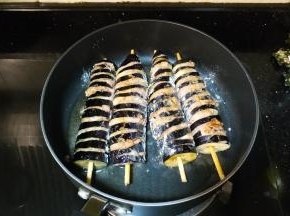 冷锅热油，放入茄子串煎至四面变软