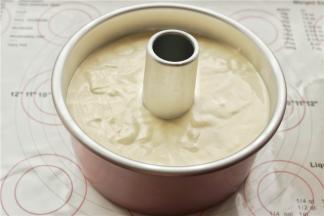 把拌好的面糊放进学厨7寸加高烟囱模具里面，两只手拿着模具，大拇指按着烟囱，用力震几下模具，震出大气泡。