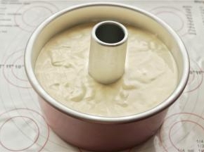 把拌好的面糊放进学厨7寸加高烟囱模具里面，两只手拿着模具，大拇指按着烟囱，用力震几下模具，震出大气泡。