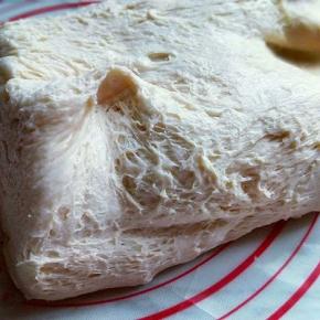 发酵好的面团从面包机取出，盖上保鲜膜排气10分钟，