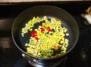 锅里继续放入麦豆、粟米粒炒均匀
