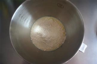 将食材A中除酵母和黄油外的食材放入厨师机打蛋盆中，装上和面勾，低速2档搅拌2分钟左右至无干粉。