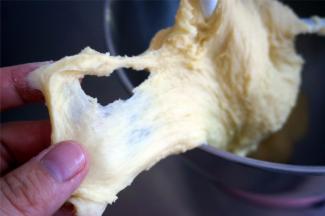 用3档快速和面2分钟，检查面团的延展性，出现面筋，加入酵母，再继续3档和面2分钟至酵母完全和面团混合。