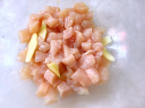 之后将鸡肉丁倒入容器内，姜切出4、5片，再加入料酒一起腌制半小时