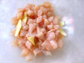 之后将鸡肉丁倒入容器内，姜切出4、5片，再加入料酒一起腌制半小时