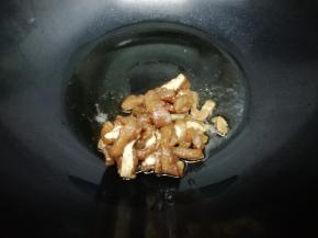 炒锅里加入适量油烧热后，把腌好的肉放入锅中煸炒到肉变色
