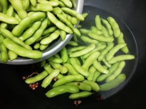 再把洗好的毛豆放入锅中大火烧开后，再转小火煮二十分钟，然后关火焖十分钟