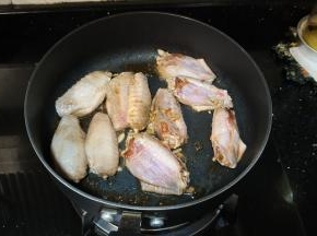 炒得差不多时把鸡翅放入锅里翻炒