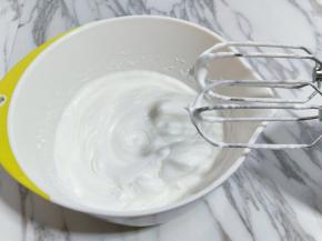 电动打蛋器高速打发，打至湿性发泡时加入最后的三分之一糖，，继续打发至蛋白出现细腻的纹路，将电动打蛋器调低速打发一会儿，感觉有些阻力时，就可以停止打发，以免消泡，提起打蛋器有微微的弯勾就可以，如图