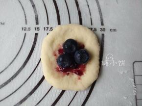 取一个小面剂压扁，包入大约3G蓝莓果酱和3-4颗洗干净的新鲜蓝莓。
因为分割大小数量可能不同，数量少而面团大就多包馅，数量多而面团小就少包馅。