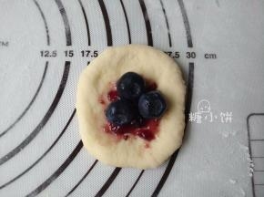 取一个小面剂压扁，包入大约3G蓝莓果酱和3-4颗洗干净的新鲜蓝莓。
因为分割大小数量可能不同，数量少而面团大就多包馅，数量多而面团小就少包馅。