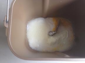 将水、酸奶、蛋液、糖、盐和奶粉倒入面包桶里