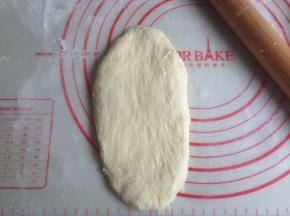 将醒发后的面团擀成椭圆形，如果有气泡就拍掉它