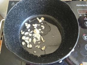 准备一个小号不粘锅，加入少许植物油热锅，蒜瓣切碎放入炒香。