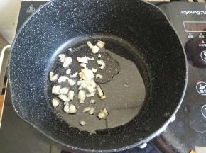 准备一个小号不粘锅，加入少许植物油热锅，蒜瓣切碎放入炒香。
