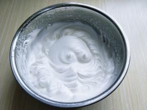 电动打蛋器高速打发，打至湿性发泡时加入最后的三分之一糖，，继续打发至蛋白出现细腻的纹路，将电动打蛋器调低速打发一会儿，感觉有些阻力时，就可以停止打发，以免消泡，提起打蛋器有微微的弯勾就可以，如图