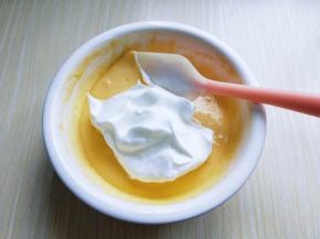 用硅胶刀取三分之一的蛋白放入蛋黄糊容易中，翻拌均匀(切记手法，不要划算搅拌，以免消泡) 从底下往上翻拌，手法要轻。