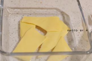 准备一个容器，将芝士片撕成条装，铺在容器底部。