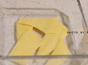 准备一个容器，将芝士片撕成条装，铺在容器底部。