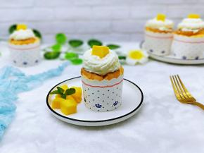 纸杯蛋糕凉后，将打发的奶油装入裱花袋中，挤在杯子蛋糕上面即可，装饰了一块芒果。