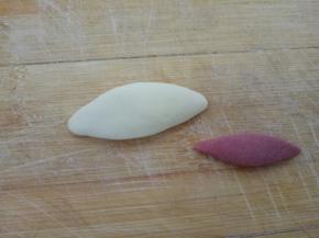 取2克白色面团和1克红色面团，分别搓成梭状，压扁