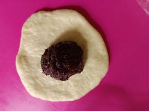 包入1个20克左右的紫米馅。像包包子一样包好。收口朝下。