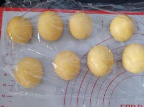 将面团平均分成4份，包入豆沙，收口向下滚圆，整形成椭圆