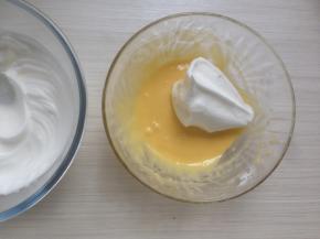 取三分之一打发好的蛋白霜到蛋黄糊里，用刮刀从底部向上翻拌均匀