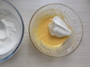 取三分之一打发好的蛋白霜到蛋黄糊里，用刮刀从底部向上翻拌均匀