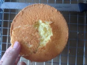 烘烤好的蛋糕取出，在桌面上震出热气，倒扣在晾架上，待放凉后脱模，底部朝上，挖出一个小洞