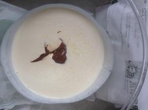 准备冰袋，垫在装有淡奶油的打蛋盆里，倒入糖和12克甘纳许，用电动打蛋器，低速搅拌至刚出现纹路即可停止。太浓稠的话，做淋面没有自然下滑的效果