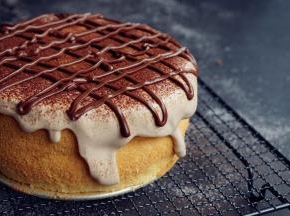 在蛋糕表面撒上可可粉，用剩余的甘纳许装在裱花袋里，挤出一条线条，装饰随意吧