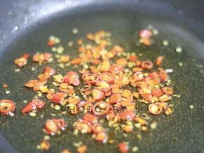 锅内热油。倒入辣酱，继续翻炒。