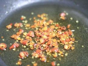 锅内热油。倒入辣酱，继续翻炒。