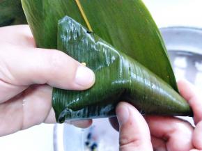 将上面的叶子放下压。将米盖住。