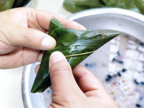 剩余部分的粽叶翻折过来包住。